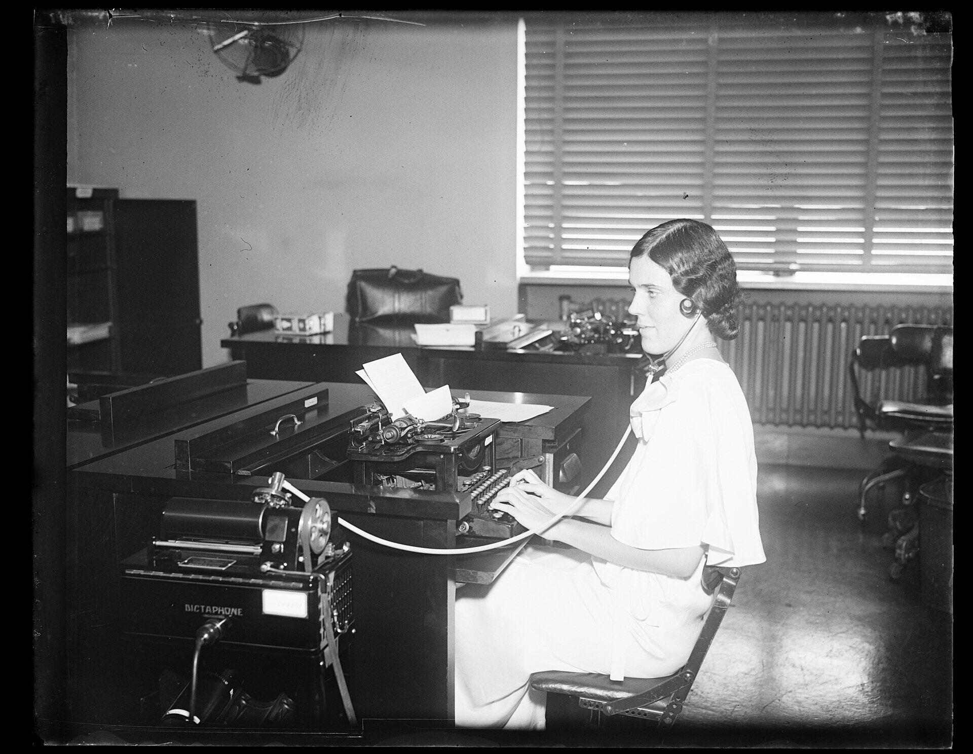 Eine Frau tippt an einer Schreibmaschine in einem Büro, 1932